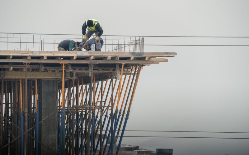 建設会社の採用サンプルサイト。高所で作業する職人たちの写真を背景にした画面